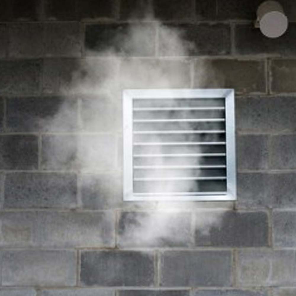 smoke escaping a vent from the side of a building